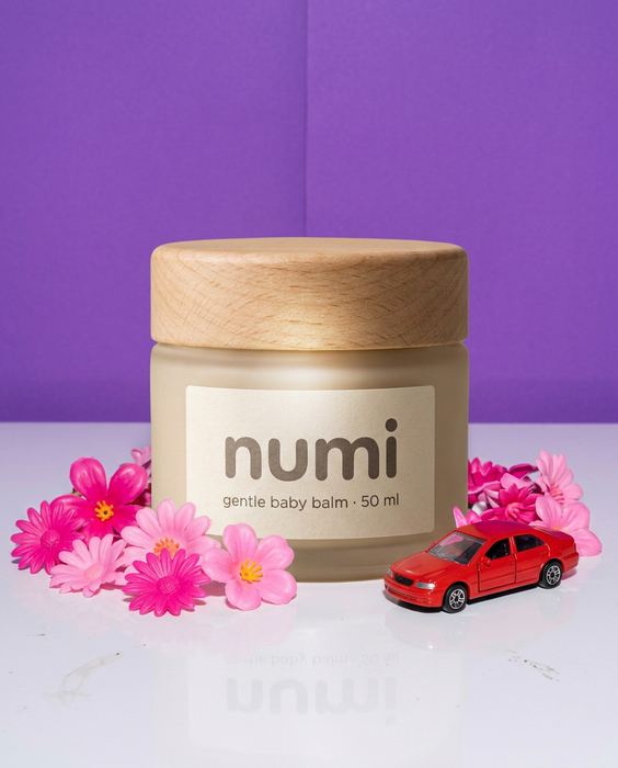 NUMI concept: the jar in a generic stock-style photo with a purple backdrop and plastic flowers