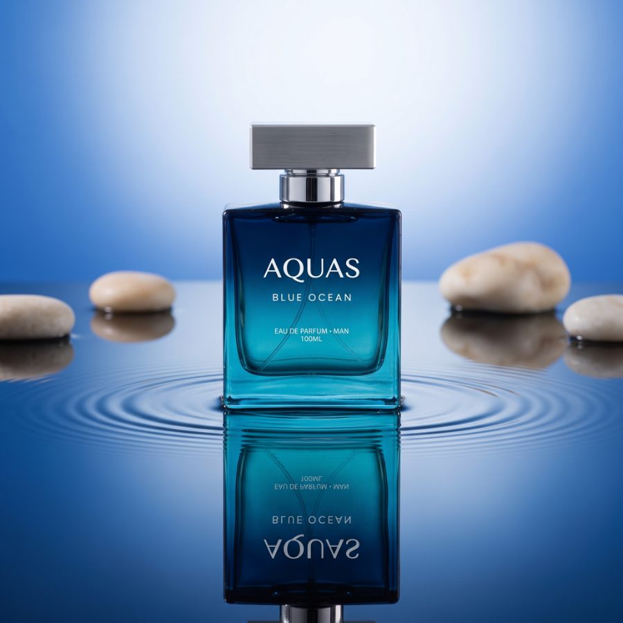 AI generated product photography for Aquas Blue Ocean fragrance brand — pebble still life