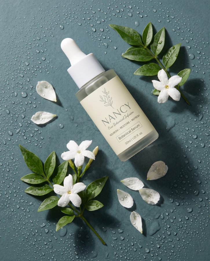 AI skincare product photography for Nancy Botanical Serum brand — flat lay